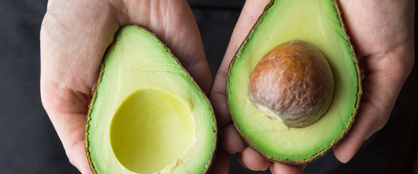 Avocado cut in half in hand